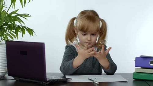 Child Doing Homework at Desk with Laptop