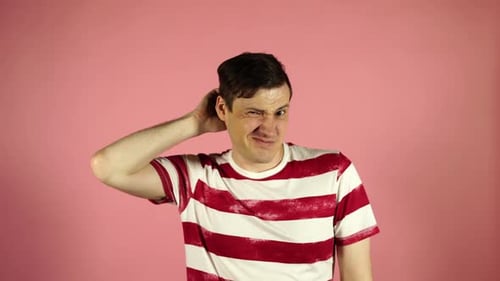 Man Scratching Head in Confusion Against Pink Background