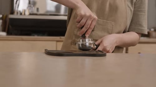 Barista Tamping Espresso Preparation in a Cafe