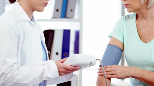 Doctor Checking Patient's Blood Pressure in Office