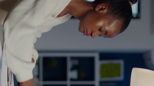 Woman Reviews Documents in Office at Night