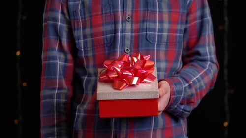 Person Holding Red Gift Box with Bow