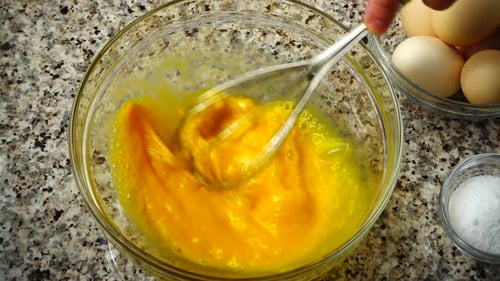 Mixing Eggs with Whisk in Bowl for Omelet