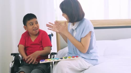 Boy in Wheelchair Plays Game with Woman