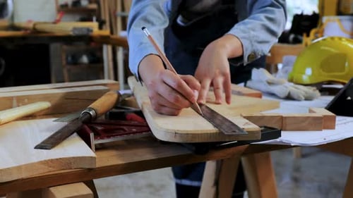 Close up of Carpenter's hand make marking line on wood for crafting in workshop factory