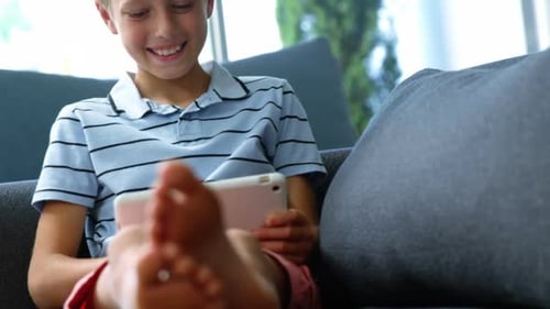 Smiling Boy Relaxing at Home With Tablet