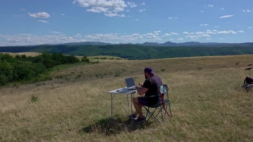 Designer gráfico com laptop trabalhando com laptop e tablet gráfico ao ar livre