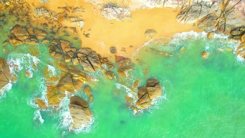 An aerial view from a drone flying over beautiful beaches and rocks