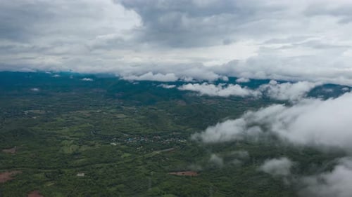 flying through the clouds above the mountain peak.
