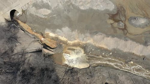 Polluted river stream with pyrite on coast 4K aerial video