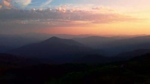 Aerial view of colorful sunrise on top of Carpathian Mountains range, morning fog