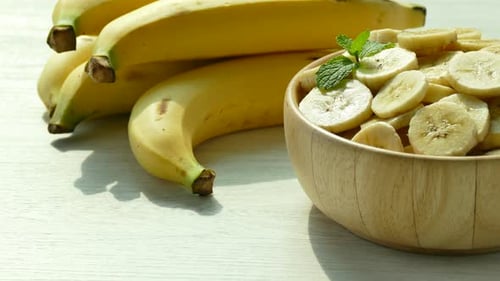 Fresh Yellow Bananas and Sliced Fruit in Bowl