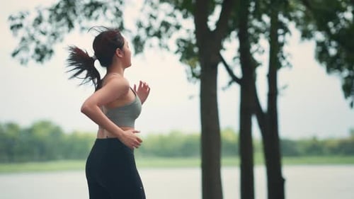 Runner young woman running in the summer park, Close up fitness female jogging outdoor.
