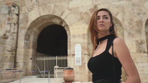 Brunette Female Tourist Walks Among Ancient Greek Ruins of Acropolis in Athens