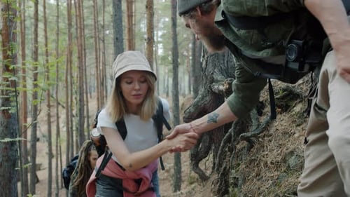 Slow Motion of Caring Man Tourist Helping Female Friends While Walking in Forest Together
