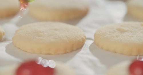 Baker preparing butter cookies with strawberry jam and powdered sugar