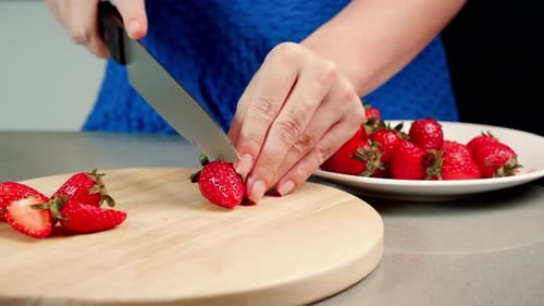 Woman Cuts Fresh Strawberries in Kitchen