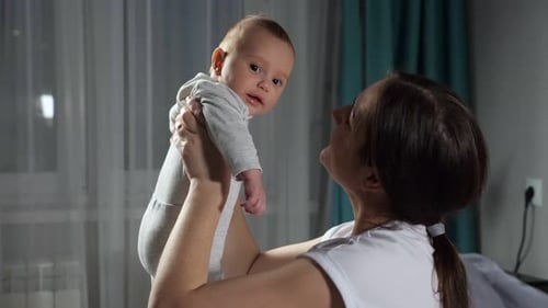 Loving Mother Holding Her Adorable Baby Upward