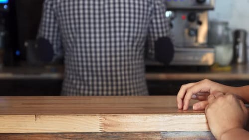 Barista Serving Mug to Customer Across Counter