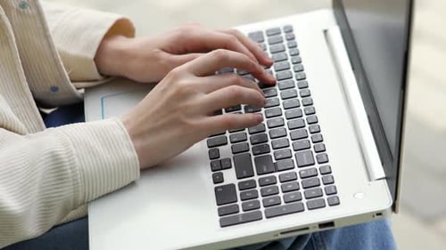 Hands Typing on Laptop Computer Keyboard Close Up