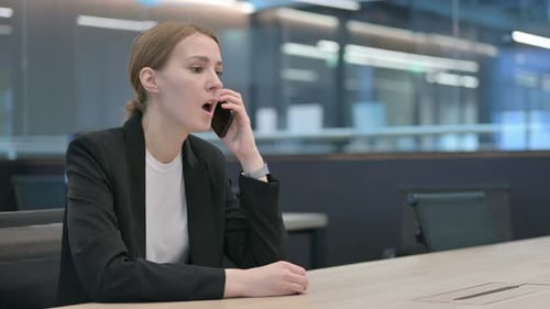 Angry Woman Arguing on Phone in Modern Office
