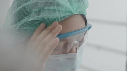 Close-up doctor or nurse exhausted suffering from a headache.