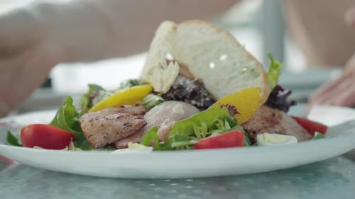 Close-up of Plate with Delicious Meat and Vegetables. Unrecognizable Caucasian Hands Turning Dish