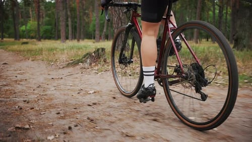 Unrecognizable Woman Athlete Riding Bicycle in Autumn Forest Pedaling Red Sports Bike on Rural Path