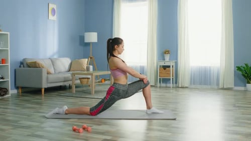 Woman Does Stretching Exercise at Home on Yoga Mat