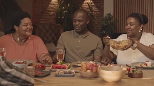 Adults Chatting and Eating Food Around Table