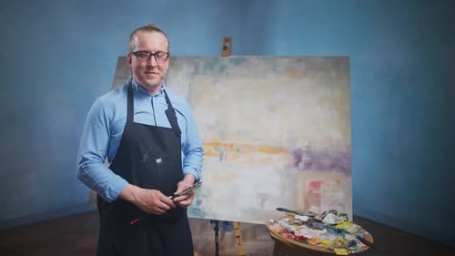 Confident Artist Stands with Painting Tools in Studio