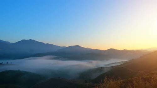 Golden Sunrise Over Mountain Range With Mist