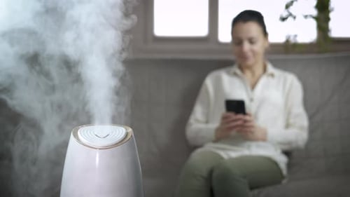Frau genießt Aromadiffusor im Haus