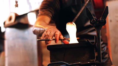 Glassblower Shaping Molten Glass with Metal Tools
