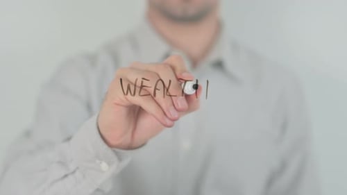 Hand Writes Word Wealth on Clear Surface