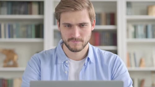Man Giving Thumbs Up While Working on Laptop