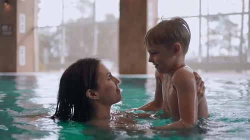 Caucasian Woman and Her Little Son are Having Fun in Swimming Pool Preschooler Boy is Teaching to