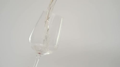 Clear Liquid Being Poured into Wine Glass