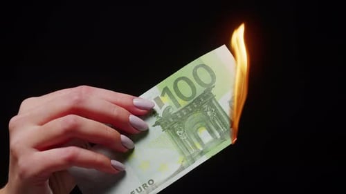 Hand Holding Burning Euro Bill in Close Up