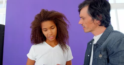 Girl and Man Looking at Camera, Studio Setting