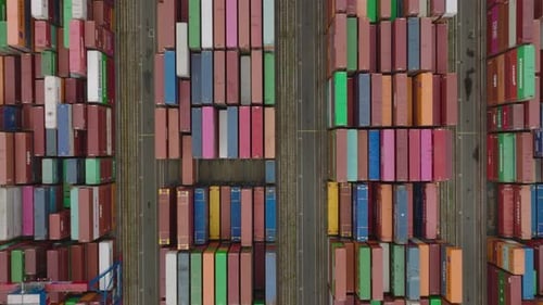 Hochwinkelansicht von Reihen von Frachtcontainern mit im Hafen gestapelten Waren