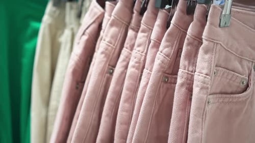 Clothes Hanger with a Variety of Denim Pants Slow Motion Soft Selective Focus Store Shelves with