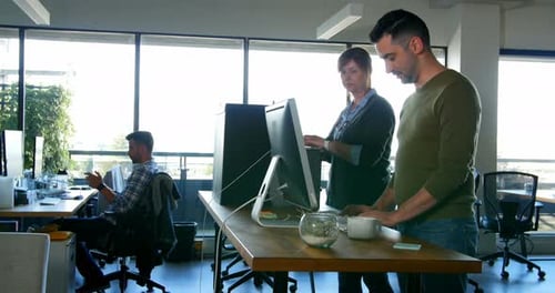 Coworkers Reviewing Computer Screen in a Modern Office