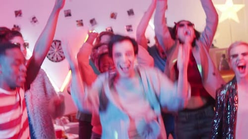 Happy Multiethnic Friends Jumping and Dancing at Cool Home Party