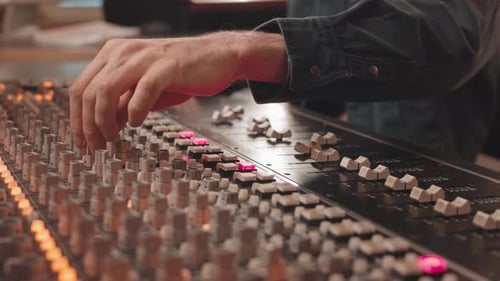 Man Working on Mixing Board at Music Studio