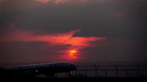 Airplane Taxiing on Runway at Sunset