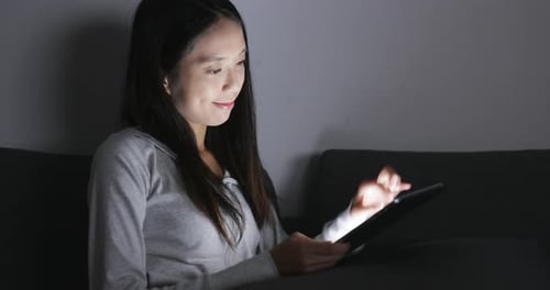 Woman using tablet computer at home
