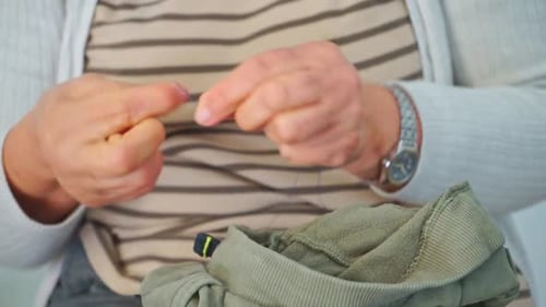 Senior Woman Threads Needle for Sewing Project