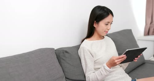 Woman Relaxing at Home with Tablet