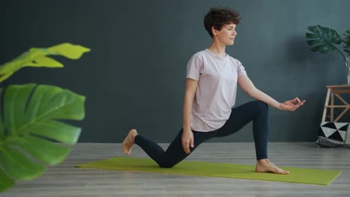 Slow Motion of Pretty Woman Doing Yoga in Gym Stretching Concentrated on Exercise